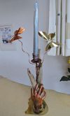 Die Standplatte ist aus Messing Antik, das Schwemmholz wird von einer Hand aus Kupfer gehalten, die Kerze zieren die Schmetterlinge aus Kupfer und Messing